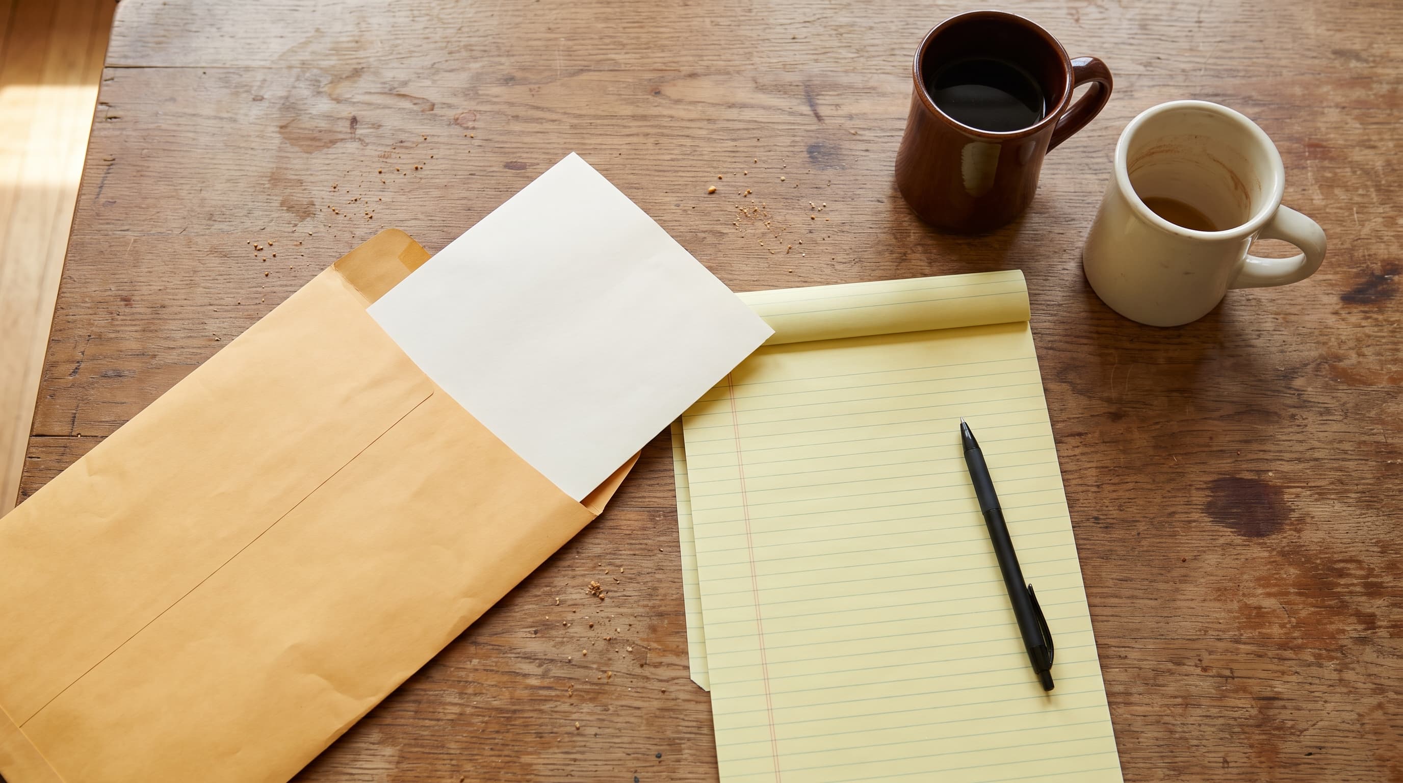 A civil demand letter shoplifting notice from a retailer's law firm lying open on a kitchen table beside an envelope